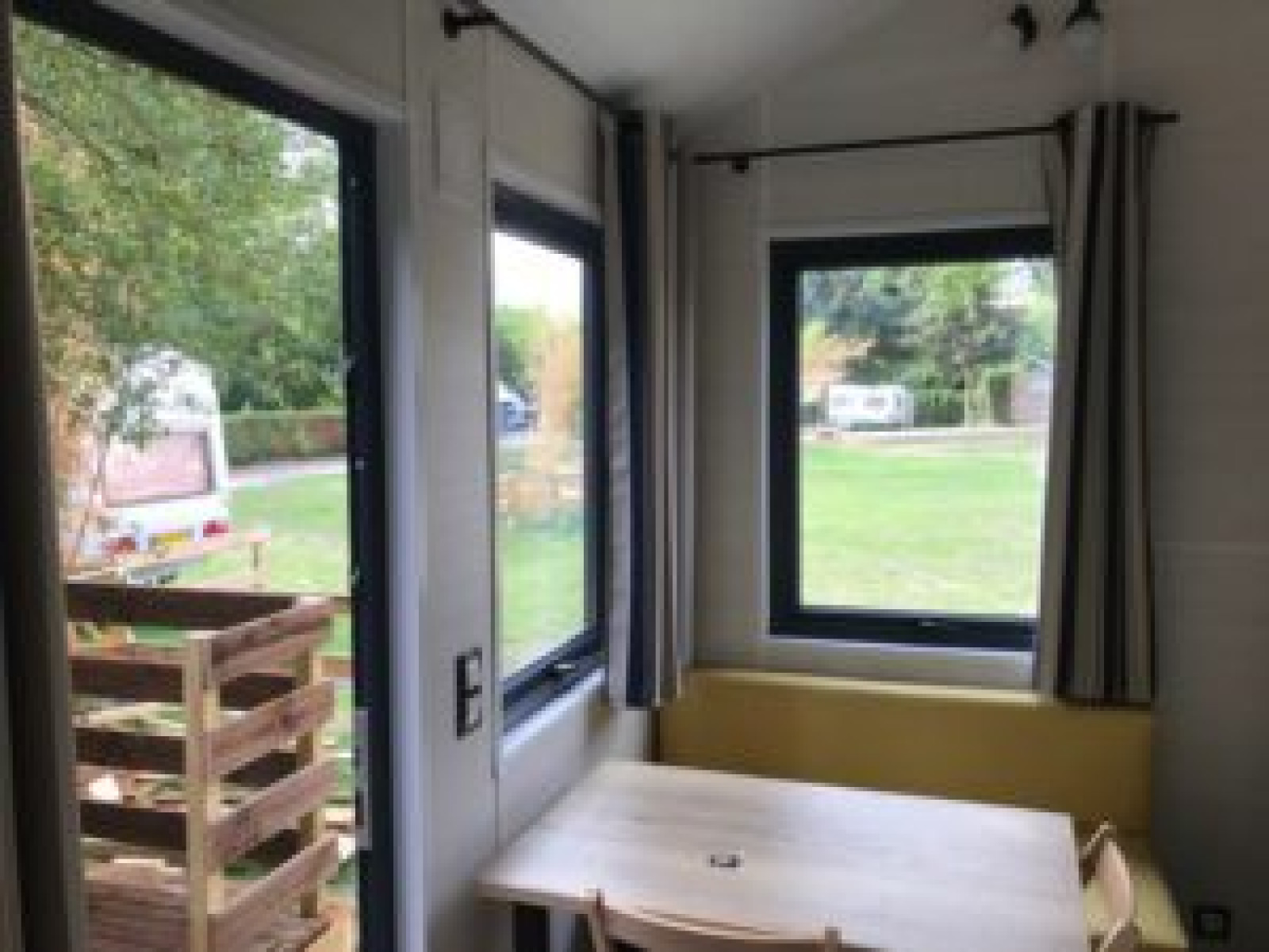 Uitzicht vanuit een Tiny House met grote ramen bij Flower Camping de la Trye in Frankrijk.