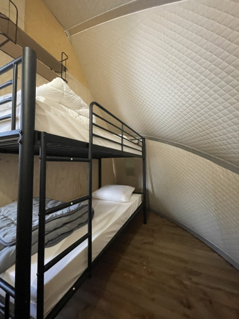 Bunk beds inside safari tent Lodge 'Big Oak XXL' at Campsite Moulin de Chaules in France with wood floor.
