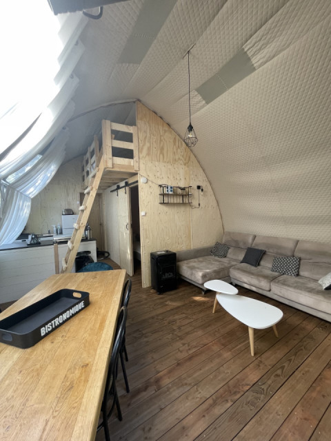 Interieur van safaritent Lodge Big Oak XXL op camping Moulin de Chaules in Frankrijk met bank en loft.