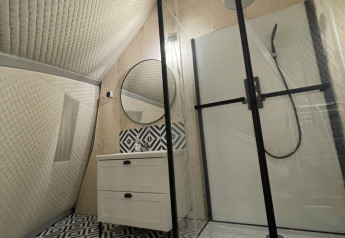 Bagno moderno in una tenda safari con pavimento geometrico bianco e nero e doccia in vetro in Francia.