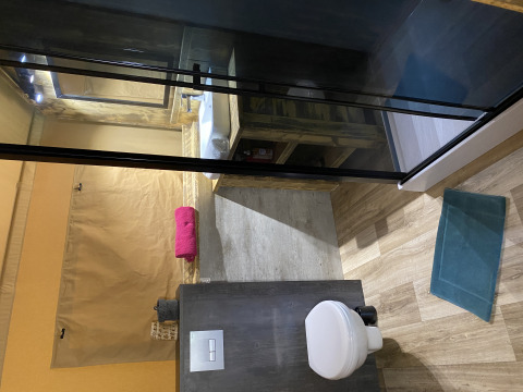 Binnenbadkamer van Woody Safari Tent met modern toilet, wastafel en kleurrijk opgerolde handdoeken.