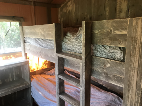 Houten stapelbedden in de Woody Safari Tent met jacuzzi op Flower Camping de la Trye in Frankrijk.