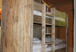 Wooden bunk beds inside a Safari Lodge XL tent at Campsite Moulin de Chaules in France.