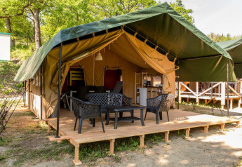 Safaritent met overdekt houten terras en tuinmeubilair bij Centro Vacanze San Marino in San Marino.
