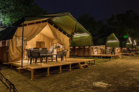 Tentes safari au Centro Vacanze San Marino à Saint-Marin, éclairées la nuit avec terrasses meublées.