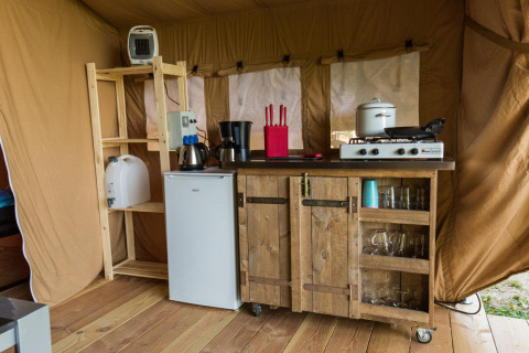 Indretning af Safari Tent ved Centro Vacanze San Marino med køkken, komfur, køleskab og træhylder.