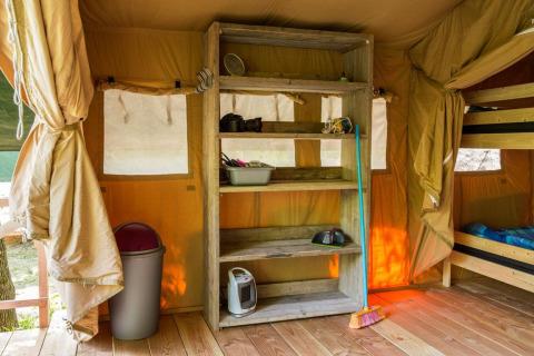Intérieur d'une tente safari au Centro Vacanze San Marino avec étagère, lits superposés et balai.