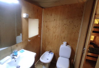 Badkamer in een safaritent bij Centro Vacanze San Marino met wastafel, toilet en bidet op houten vloer.