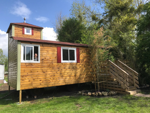 Een houten tiny house genaamd Château Mobile met jacuzzi bij Flower Camping de la Trye in Frankrijk.