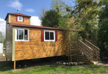 Une tiny house en bois nommée Château Mobile avec jacuzzi au Flower Camping de la Trye en France.