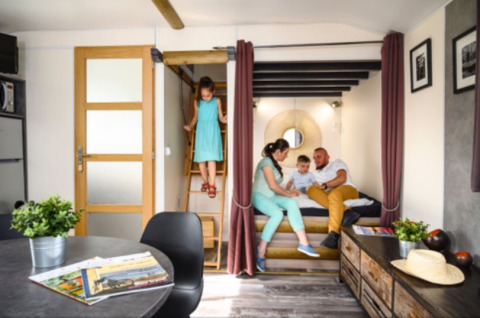 Gezin ontspant in een modern tiny house bij Flower Camping de la Trye in Frankrijk.