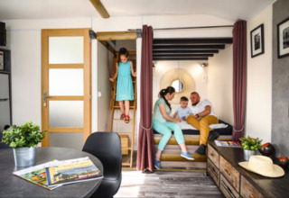 Gezin ontspant in een modern tiny house bij Flower Camping de la Trye in Frankrijk.