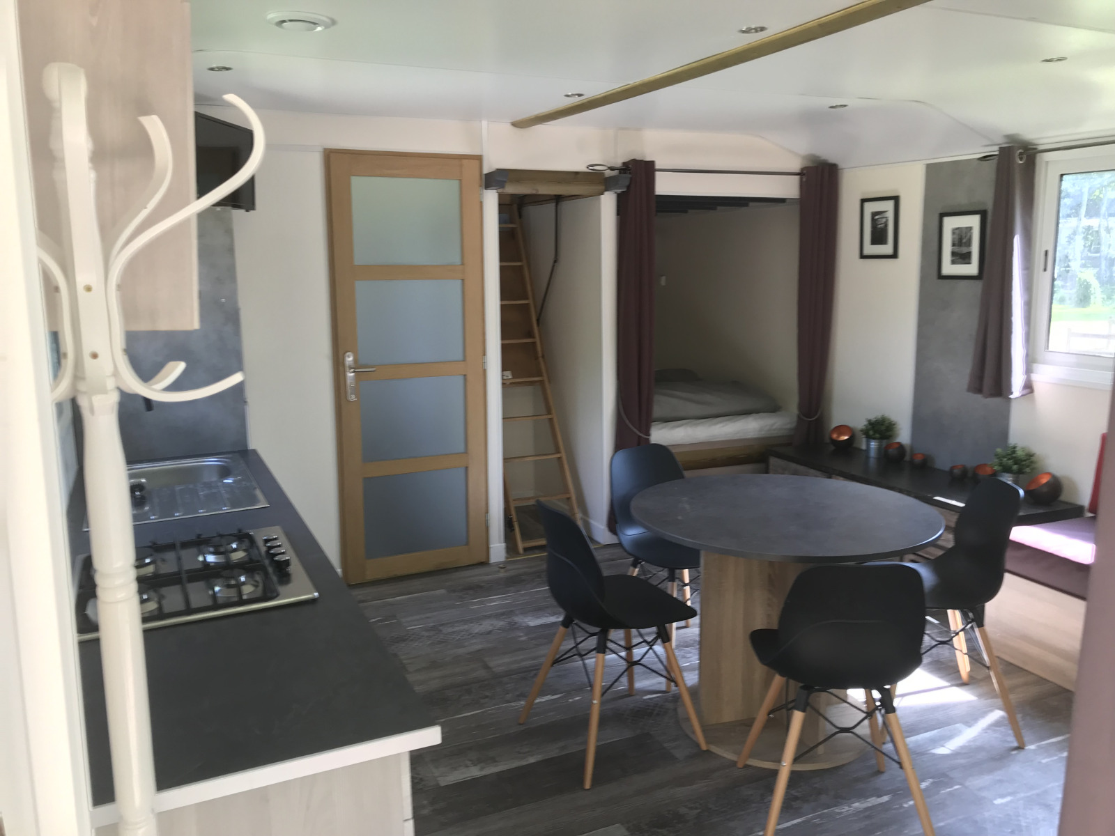 Interieur van Château Mobile + jacuzzi bij Flower Camping de la Trye, met keuken en eethoek.