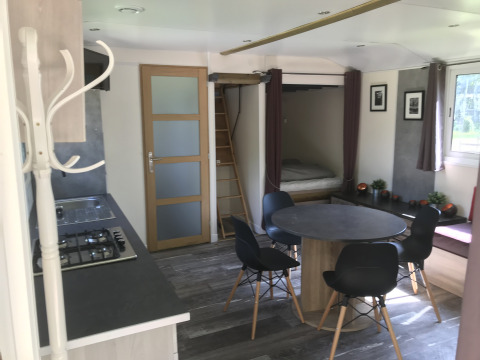 Interieur van Château Mobile + jacuzzi bij Flower Camping de la Trye, met keuken en eethoek.