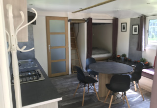 Interieur van Château Mobile + jacuzzi bij Flower Camping de la Trye, met keuken en eethoek.