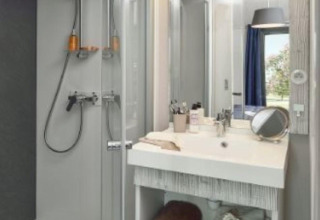 Bagno moderno con doccia, lavabo, specchio e asciugamani in uno chalet di legno a Moulin de Chaules, Francia.