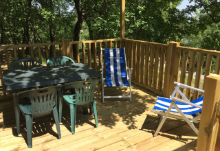 Terrazza in legno con tavolo di plastica, quattro sedie e due sdraio presso Air Lodge, Centro Vacanze San Marino.
