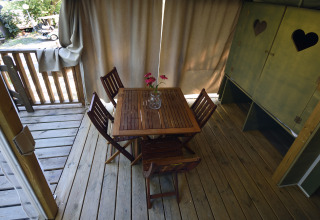 Terraza de madera con mesa y cuatro sillas en la tienda Air Lodge en Centro Vacanze San Marino.