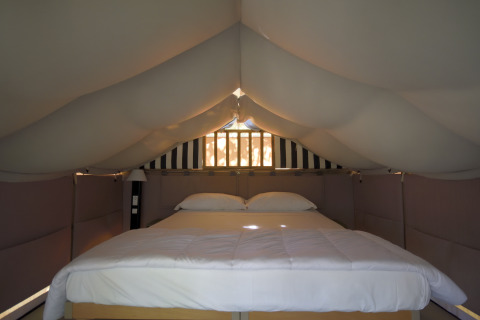 Letto matrimoniale nella tenda safari «Air Lodge» al Centro Vacanze San Marino, soffitto e pareti imbottiti.