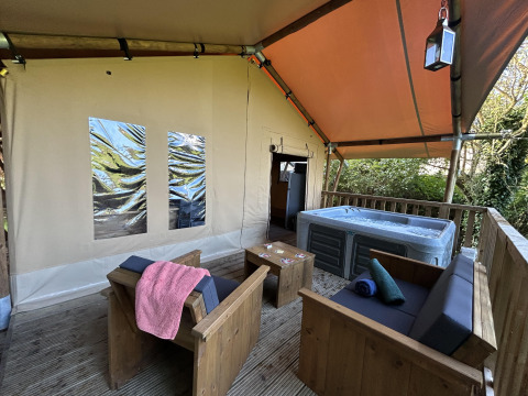 Safari Tent XXL met buitenjacuzzi en houten zitjes bij Flower Camping de la Trye in Frankrijk.
