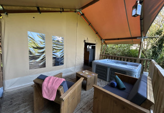 Safari Tent XXL met buitenjacuzzi en houten zithoek bij Flower Camping de la Trye in Frankrijk.
