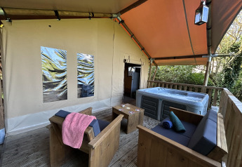 Safari-telt XXL med udendørs jacuzzi og træmøbler på Flower Camping de la Trye, Frankrig.