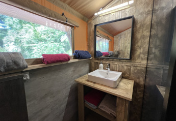 Baño en la Safari Tent XXL con lavabo, espejo y toallas en Flower Camping de la Trye, Francia.