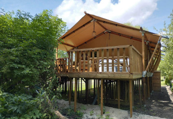 Safari-Zelt XXL mit Außen-Whirlpool auf Flower Camping de la Trye in Frankreich, auf Stelzen.