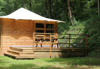 Baita in legno con terrazza, tavolo da picnic e sdraio nel bosco, Lodge Bali, Moulin de Chaules, Francia.