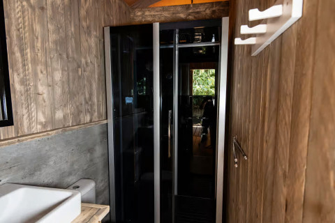 Salle de bain moderne en bois et verre dans l’hébergement glamping Centro Vacanze San Marino - Safaritenten.