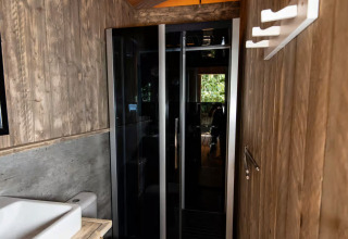 Salle de bain moderne en bois et verre dans l’hébergement glamping Centro Vacanze San Marino - Safaritenten.
