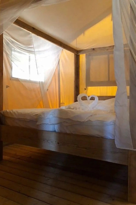 Hébergement glamping de luxe avec lit à baldaquin et moustiquaire à Centro Vacanze San Marino Safaritenten.