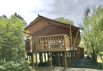 Safari-tent XXL met jacuzzi bij Flower Camping de la Trye in Frankrijk, op palen tussen het groen.