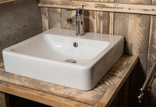 Lavandino bianco moderno con rubinetto cromato in bagno rustico al glamping Centro Vacanze San Marino.