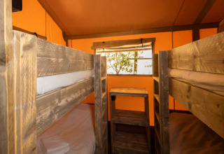Intérieur d'une tente glamping avec lits superposés en bois au Centro Vacanze San Marino - Safaritenten San Marino.