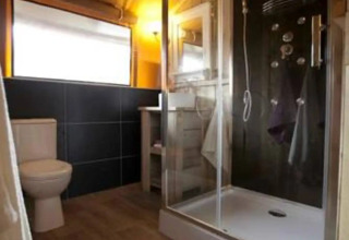 Moderne badeværelse i glamping safari telt på Centro Vacanze San Marino med bruser og toilet.