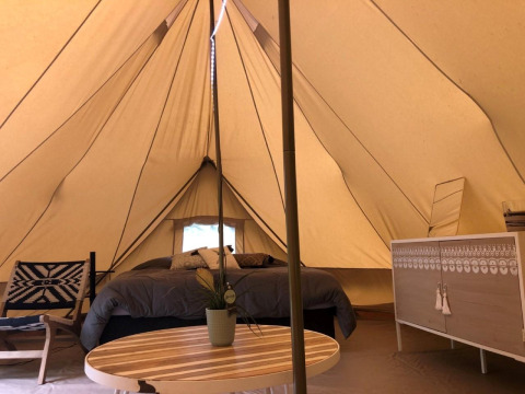 Interno della tenda safari 'Emperor Bell Tent' al campeggio Moulin de Chaules in Francia, arredi accoglienti.