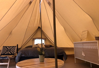Interior of the safari 'Emperor Bell Tent' at Campsite Moulin de Chaules, France, with cozy furnishings.