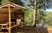 Outdoor kitchen and seating area at Emperor Bell Tent, Campsite Moulin de Chaules, surrounded by nature.