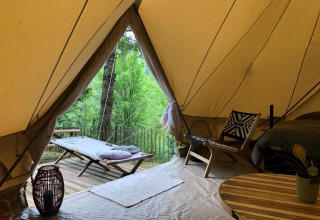 Interno della tenda safari 'Emperor Bell Tent' al campeggio Moulin de Chaules in Francia con vista sul verde.