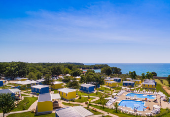 Blick auf bunte Hütten und Pool im Miramí Family Village im Aminess Planet Camping Maravea Resort, Kroatien.