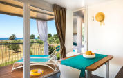 Interno luminoso di una casa vacanze con tavolo da pranzo e terrazza vista mare in Croazia.
