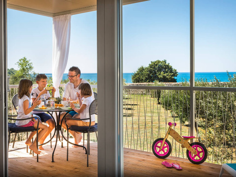 Gezin geniet van ontbijt op terras met zeezicht in Miramí Family Village, Aminess Maravea Resort in Kroatië.