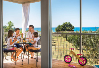 Familie frühstückt auf der Terrasse mit Meerblick in der Miramí Family Village im Aminess Maravea Resort Kroatien.