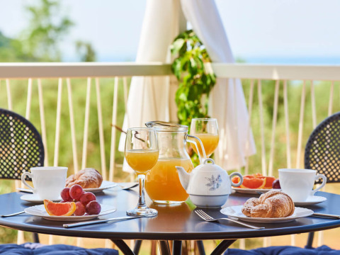 Ontbijt op balkon met croissants, verse jus, thee en fruit bij Miramí Family Village in Kroatië.