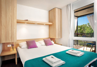 Gezellige slaapkamer in Maravea Family Holiday Home bij Aminess Planet Camping Maravea Resort in Kroatië met balkon.