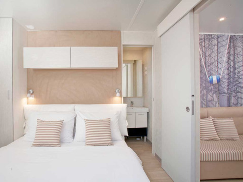 Lichte moderne slaapkamer in Marina Home, Valamar Camping Marina Kroatië, met tweepersoonsbed en stijlvolle inrichting.