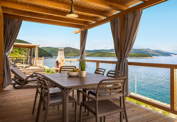 Terrasse couverte avec table à manger, chaises et vue spectaculaire sur la mer à Marina Home Spectacular Seaview, Camping Valamar Marina, Croatie.