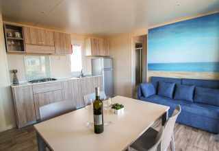 Modern Park Riviera 2-bedroom lodge at Campsite Park Umag, Croatia, featuring a kitchen, dining area and sofa.