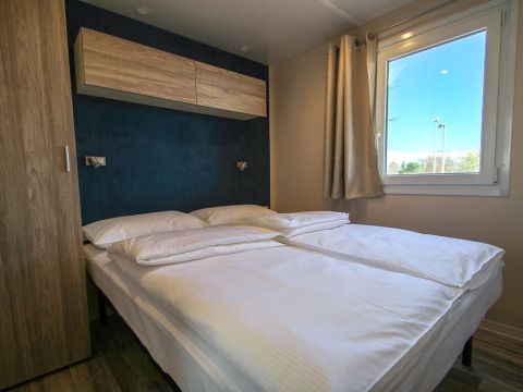 Modern double bedroom with large window at Park Riviera 2-bedroom lodge in Campsite Park Umag, Croatia.